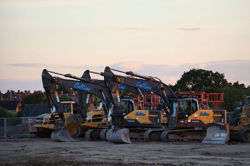 Excavators lined up on a UK construction site at sunset